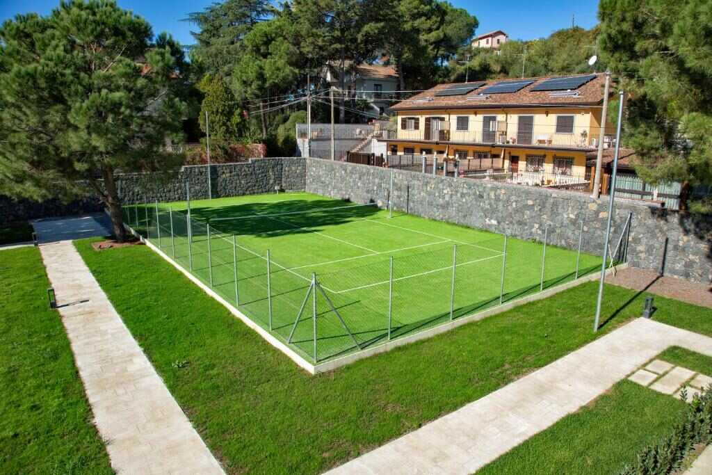 Tennis court surrounded by pines and lava stone walls